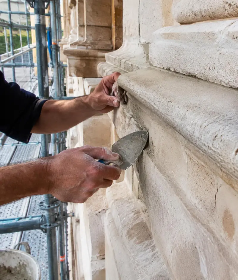 Reprise d'un joint à la truelle sur une façade en pierre